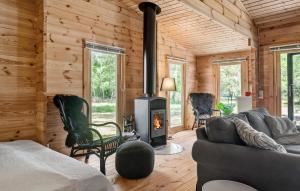 a living room with a fireplace in a log cabin at Awesome Home In Gedser With Wifi in Gedser