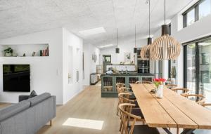 a dining room and living room with a wooden table and chairs at Amazing Home In Rødby With Sauna in Rødby