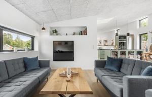 a living room with a couch and a table at Amazing Home In Rødby With Sauna in Rødby