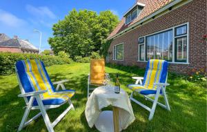 two chairs and a table on a lawn at Hoeve Aan De Waddenzee in Wierum