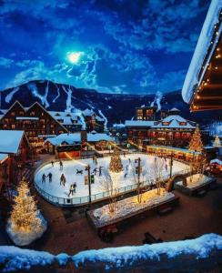 a group of people skating on an ice rink at night at Spruce Peak Resort luxury 3 Bedrm 2levelApartment in Stowe