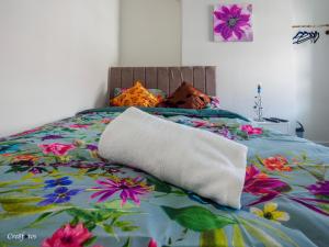 a bed with a floral bedspread with a pillow on it at Newlands Lodge Deluxe Family Room 2 in Stoke on Trent