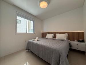 a bedroom with a large bed and a window at IL01- Vista Mar | Pé na Areia | Churrasqueira in Itapema