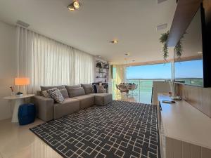 a living room with a couch and a view of the ocean at IL01- Vista Mar | Pé na Areia | Churrasqueira in Itapema