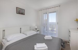 a white bedroom with a bed with two towels on it at Nice Apartment In Barbat With Wifi in Barbat na Rabu