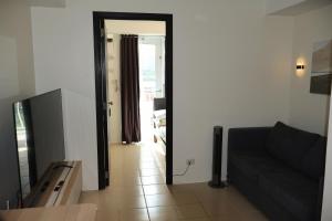 a living room with a couch and a television at Kasara Urban Resort Elly's Pad with balcony in Manila +35 photos