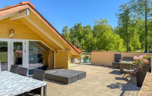 a patio with a table and chairs and a house at Holiday Home Fjordparken Hadsund Iii in Odde +18 photos