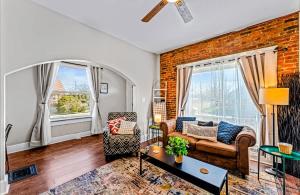 a living room with a couch and a brick wall at Stylish Home in Historic District Near Riverwalk in Jeffersonville