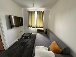 a living room with a couch and a table at Airrose Tranquil in Tettenhall