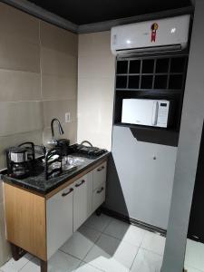 a kitchen with a white refrigerator and a sink at Loftjesus in Campina Grande