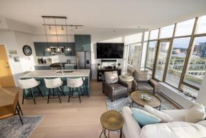 an open living room with a kitchen and a living room at Victoria's SEA-Cret-Stunning Olympic and Inner Harbour Views from 450 sq ft Balcony in Victoria