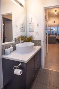 a bathroom with a sink and a mirror at Victoria's SEA-Cret-Stunning Olympic and Inner Harbour Views from 450 sq ft Balcony in Victoria