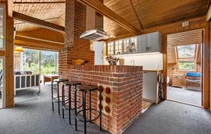 a kitchen with a brick counter with stools at Holiday Home Skovbrynet Tarm V in Hemmet +24 photos