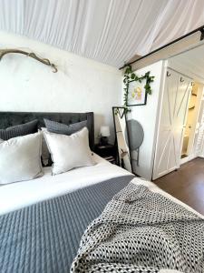 a bedroom with a large bed with white sheets at Antler & Oak Cottage: Provincial Luxe In Moss Vale in Moss Vale