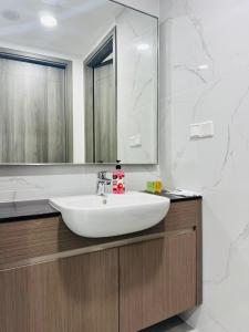 a bathroom with a white sink and a mirror at My Service Suites Agile KL in Kuala Lumpur