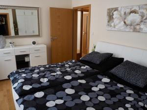 a bedroom with a black and white comforter on a bed at Balconies above colonnade in Mariánské Lázně +20 photos