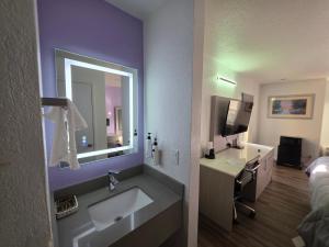 a bathroom with a sink and a mirror at The Aqua Pacific Hotel in Santa Cruz +22 photos