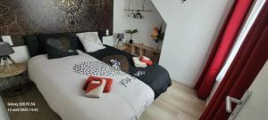 a bedroom with two beds with red and white pillows at Les Volets Bleus - Au Calme avec petit Jardin et Patio - 3 appartements in Bourges