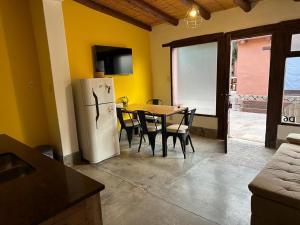 a kitchen with a table and a white refrigerator at Aparthotel Ruta 52 in Purmamarca