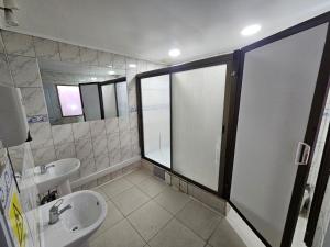 Un baño con lavabo, inodoro y espejo. en Hostal G&P, en Antofagasta 16 fotos más