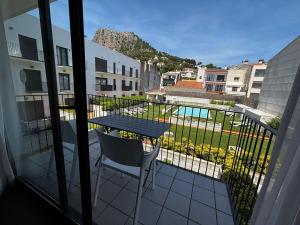 einen Balkon mit einem Tisch und Poolblick in der Unterkunft Apartamento céntrico con piscina, parking y a 200m de la playa en L'Estartit - ES-323-41 in L'Estartit
