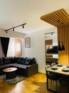 a living room with a black couch and a table at Belle Vue Apartmani in Zlatibor