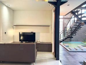 a living room with a tv and a swimming pool at Villa Shinta1 with 3 BR, Pool & WiFi in Ungasan Bali by Damaresa in Uluwatu