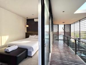 a bedroom with a bed and a balcony at Villa Shinta1 with 3 BR, Pool & WiFi in Ungasan Bali by Damaresa in Uluwatu +61 photos