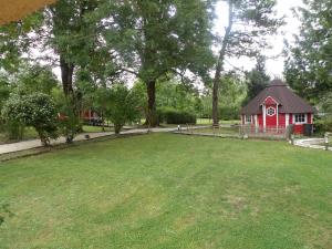 a small red building with a clock tower in a yard at L'auberge du moulin a grains in Ménil-la-Horgne +14 photos