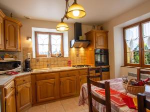 a large kitchen with wooden cabinets and a table at Maison Périgourdine avec piscine, WiFi, animaux acceptés - FR-1-616-77 in Daglan