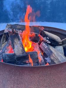 a fire pit with wood and flames in it at Isca House, Exeter, NSW in Exeter