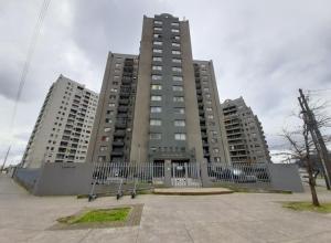 un edificio alto con una valla delante en Amplio Departamento en Centro de Concepción con estacionamiento 2D-2B, en Concepción