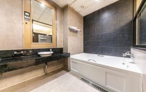 a bathroom with a tub and a sink at Nowon Ritz Hotel in Seoul