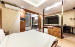 a hotel room with a bed and a flat screen tv at Nowon Ritz Hotel in Seoul +5 photos