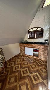 a kitchen with a wooden floor in a attic at Chalé Paraíso Guararema 2 in Guararema