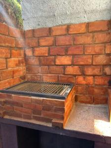 a brick wall with a bed in front of it at Chalé Paraíso Guararema 2 in Guararema