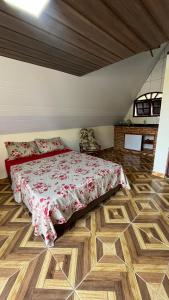 a bedroom with a bed and a wooden floor at Chalé Paraíso Guararema 2 in Guararema