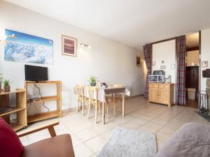 a living room with a table and a kitchen at Appartement à Saint Lary, proche pistes, animaux admis - FR-1-296-519 in Saint-Lary-Soulan