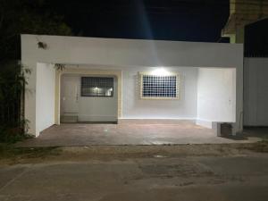 a white house with a garage at night at Colibrí Apartment in Valladolid