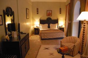 een slaapkamer met een bed en een stoel in een kamer bij Les Borjs De La Kasbah in Marrakesh