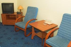 a room with two chairs and a table and a tv at Hotel Kujawy in Włocławek
