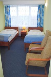 une chambre d'hôtel avec deux lits et une chaise dans l'établissement Hotel Kujawy, à Włocławek