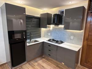 a kitchen with a black refrigerator and a sink at Bhurban Suites in Bhurban