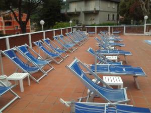 una fila de sillas azules sentadas en un patio en Residence i Morelli, en Pietra Ligure