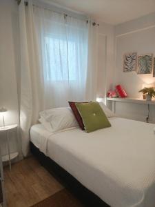 a bedroom with a white bed with a window at New! Cozy Cool Studio Near Beach! in San Juan