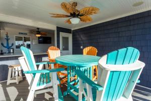 a blue table and chairs on a porch with a kitchen at 5062 - Our Bright Idea in Kill Devil Hills