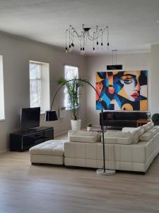 a living room with a white couch and a painting at Aste loft in Aste