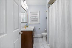 a white bathroom with a toilet and a sink at Stylish 3 bedroom near Downtown Providence & Providence College in Providence +12 photos