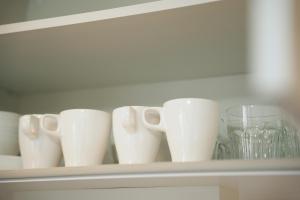 a shelf with a bunch of white cups on it at Color Tsuruhashi in Osaka