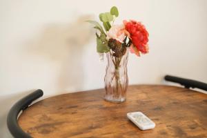 a vase of flowers on a table with a remote control at Color Tsuruhashi in Osaka